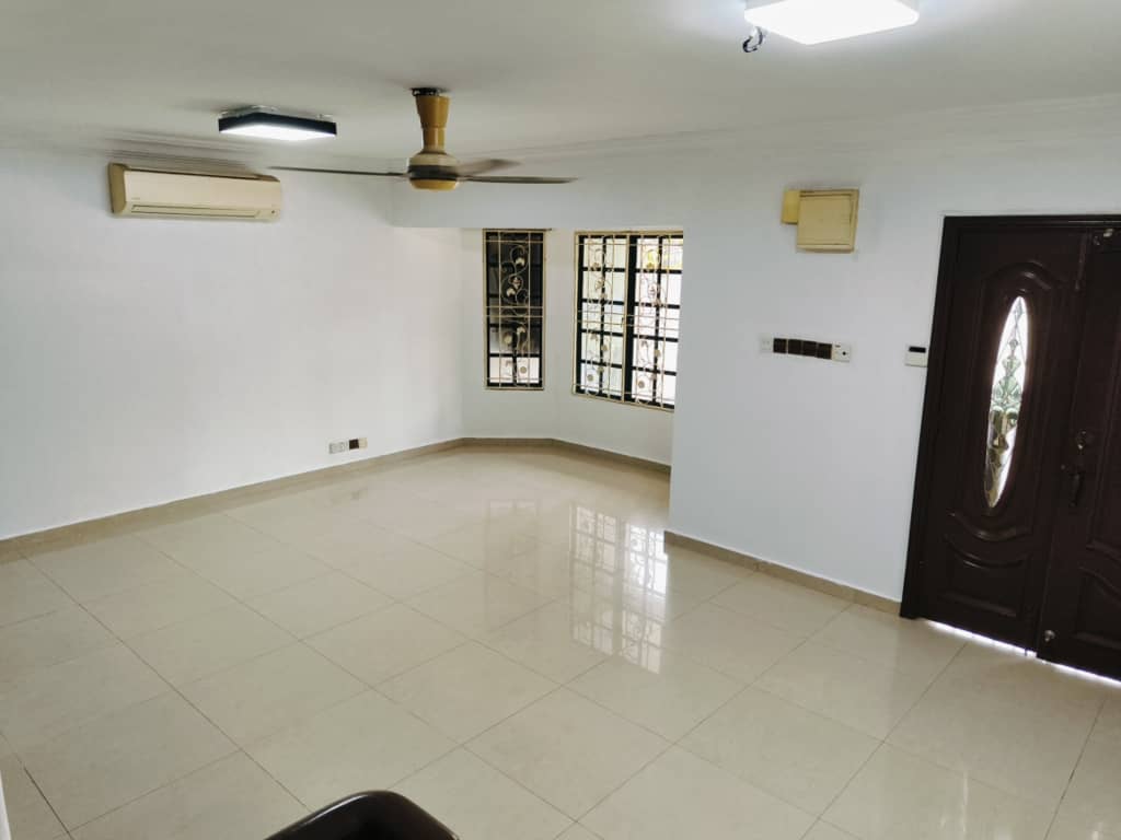 Tiled living area with ceiling fan and entrance door
